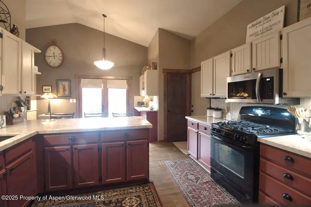 a kitchen with stainless steel appliances a stove a sink cabinets and a refrigerator