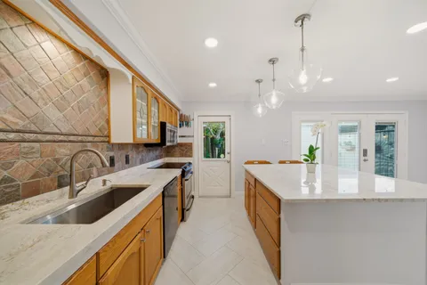 a kitchen with a sink stove top oven and refrigerator