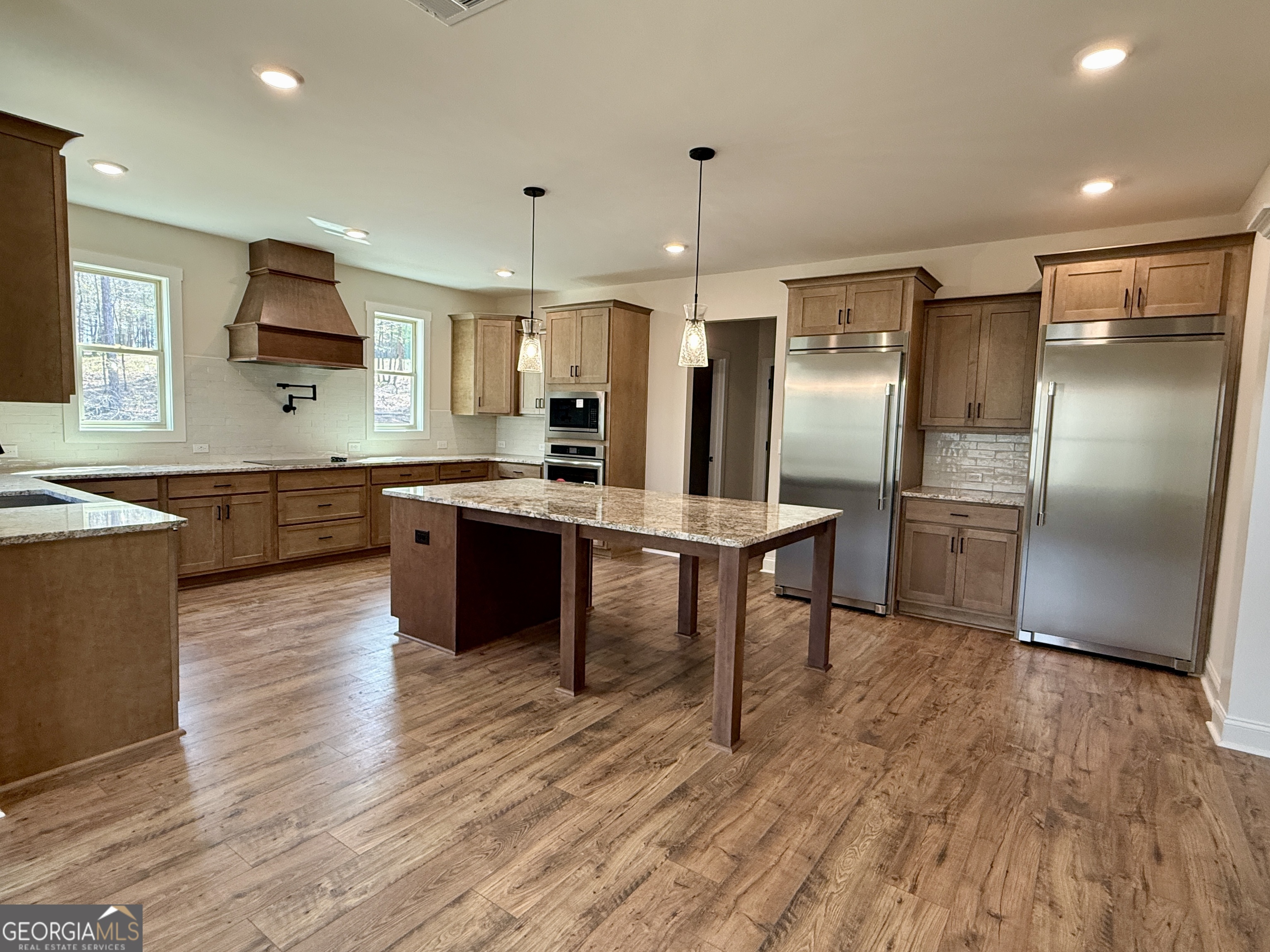 360 Indian Trail Concord, GA 30206 - Photo 16 of 67 a kitchen with stainless steel appliances granite countertop a refrigerator a sink dishwasher a stove and white countertops with wooden floor
