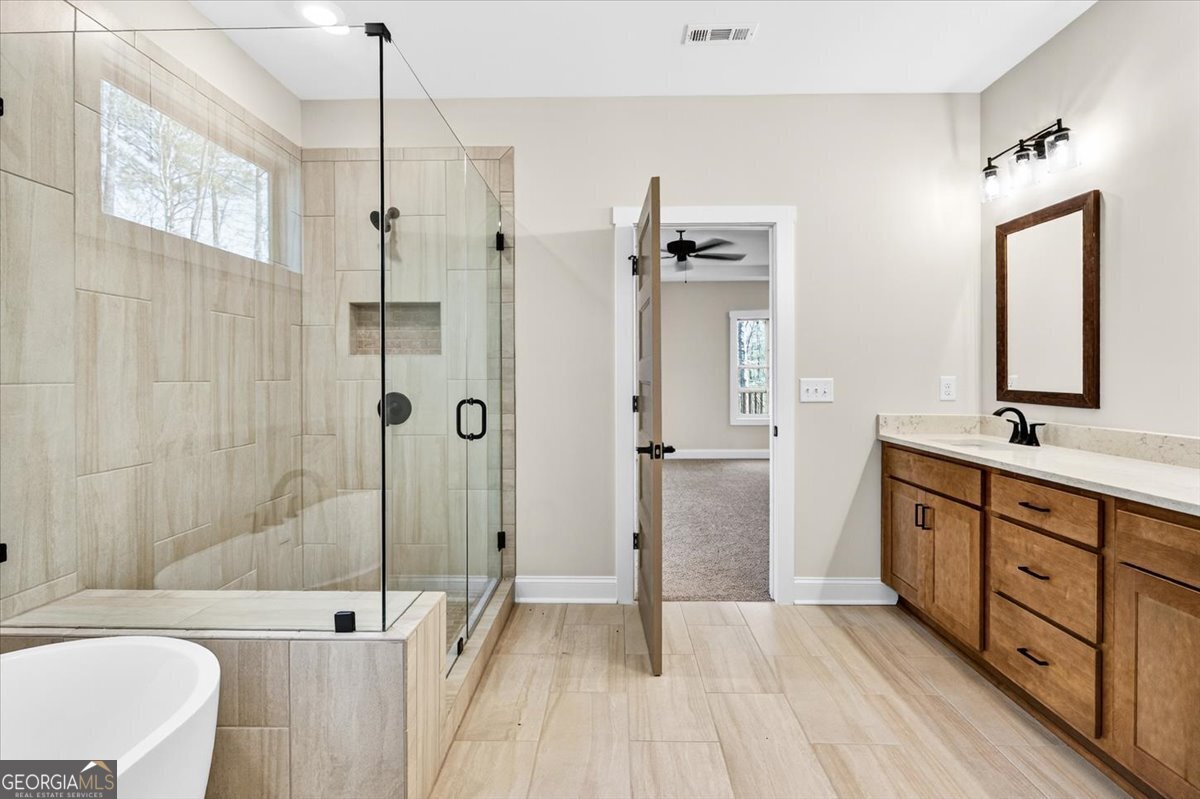360 Indian Trail Concord, GA 30206 - Photo 24 of 67 a spacious bathroom with a double vanity sink a mirror and a shower
