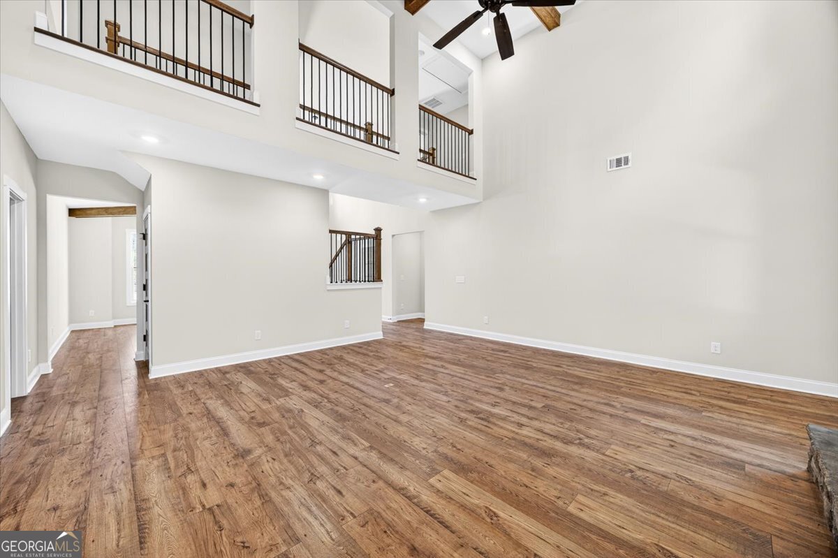 360 Indian Trail Concord, GA 30206 - Photo 10 of 67 a view of an empty room with wooden floor and a ceiling fan