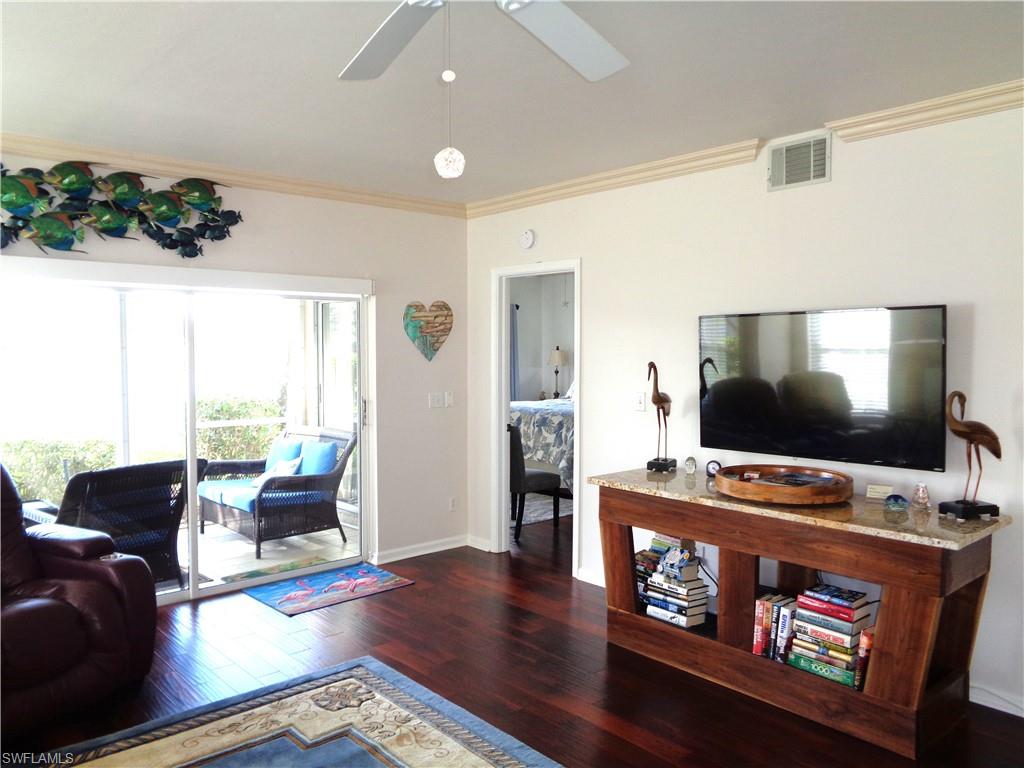 6260 Bellerive Avenue, Unit 4 Naples, FL 34119 - Photo 11 of 36 a living room with furniture and a flat screen tv