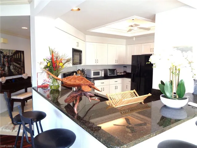 a living room with furniture kitchen view and a large mirror