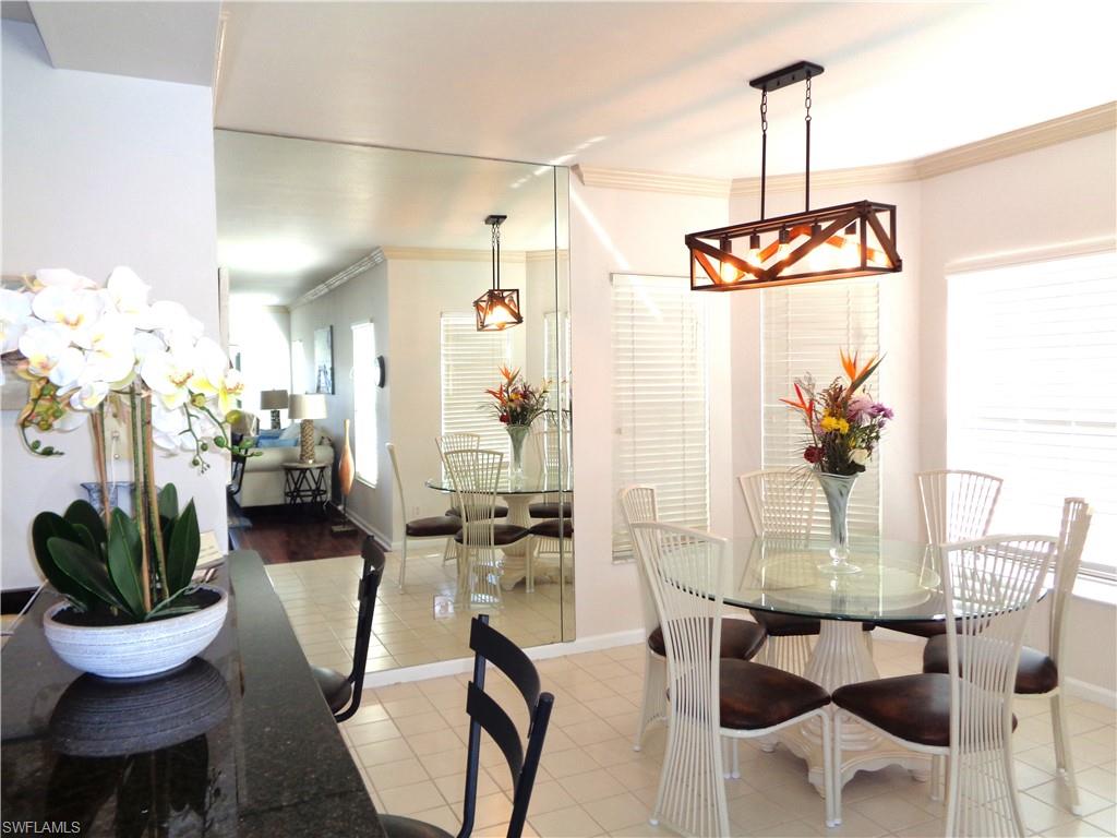 6260 Bellerive Avenue, Unit 4 Naples, FL 34119 - Photo 17 of 36 a view of a dining room with furniture window and outside view