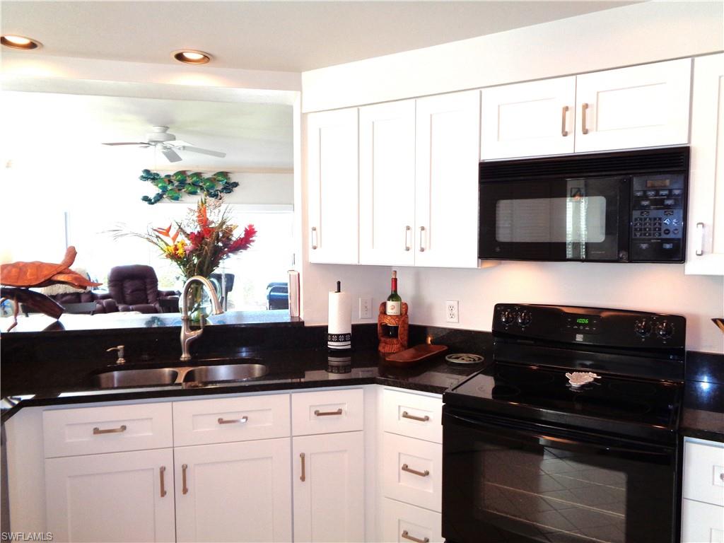 6260 Bellerive Avenue, Unit 4 Naples, FL 34119 - Photo 18 of 36 a kitchen with a sink and cabinets
