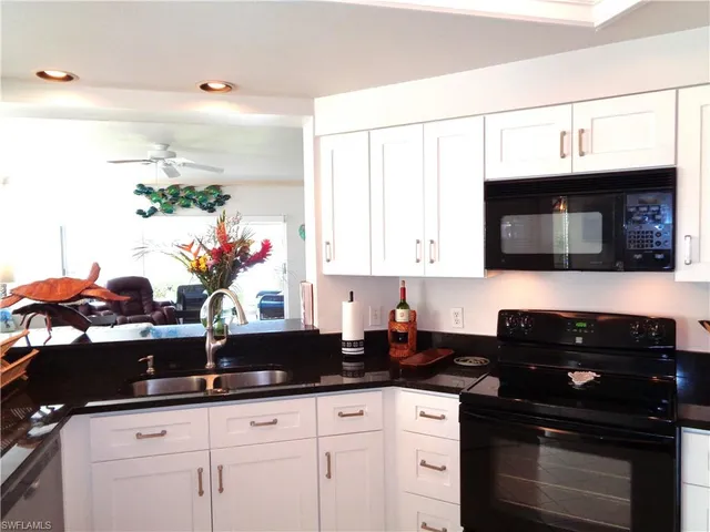 a kitchen with a sink dishwasher and a stove with wooden floor