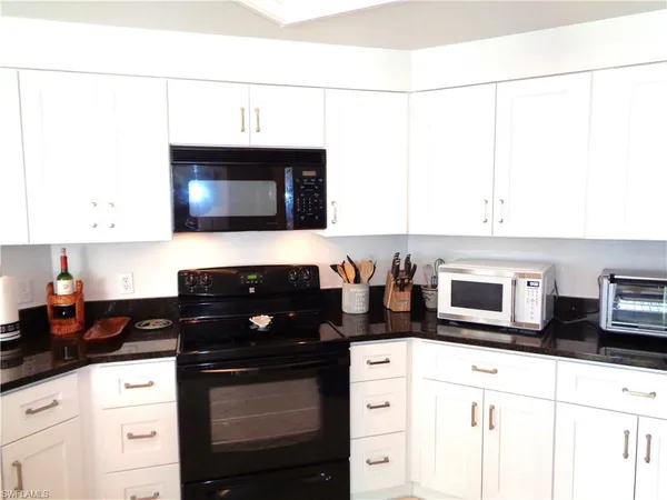 a kitchen with stainless steel appliances a stove a microwave a sink and cabinets