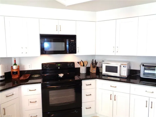 a kitchen with stainless steel appliances a stove a microwave a sink and cabinets