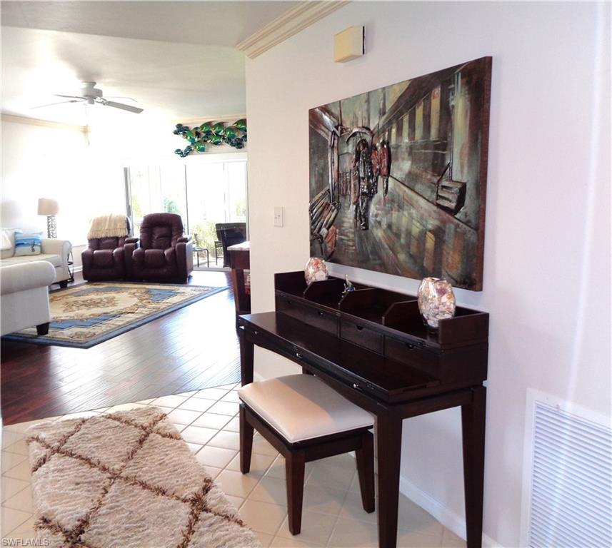 6260 Bellerive Avenue, Unit 4 Naples, FL 34119 - Photo 22 of 36 a living room with furniture and a painting on the wall
