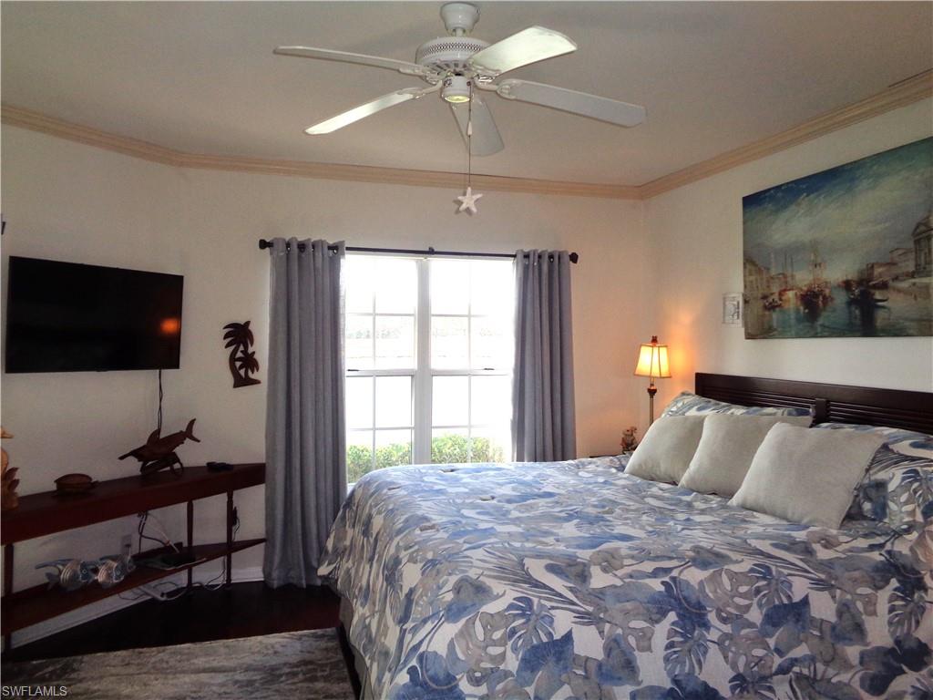 6260 Bellerive Avenue, Unit 4 Naples, FL 34119 - Photo 24 of 36 a bedroom with a bed and a flat screen tv
