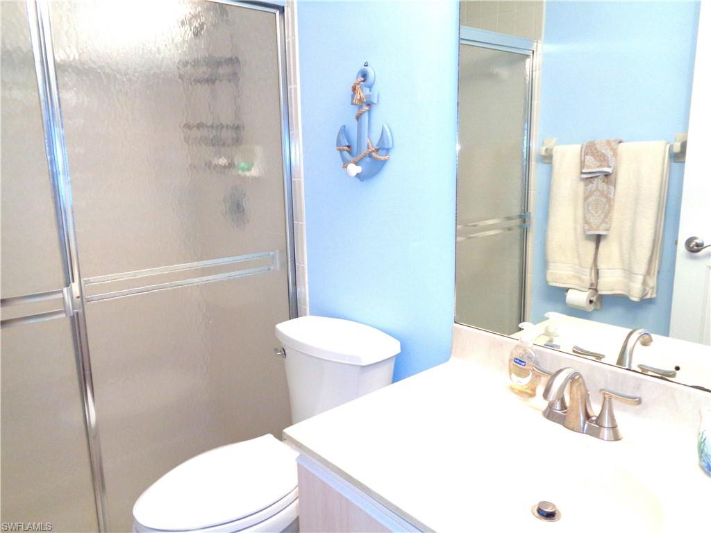 6260 Bellerive Avenue, Unit 4 Naples, FL 34119 - Photo 27 of 36 a bathroom with a sink a toilet and shower