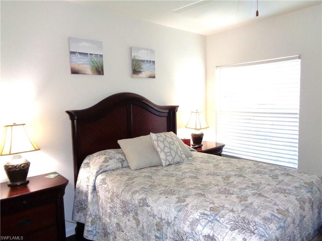 6260 Bellerive Avenue, Unit 4 Naples, FL 34119 - Photo 29 of 36 a bedroom with a bed and a window