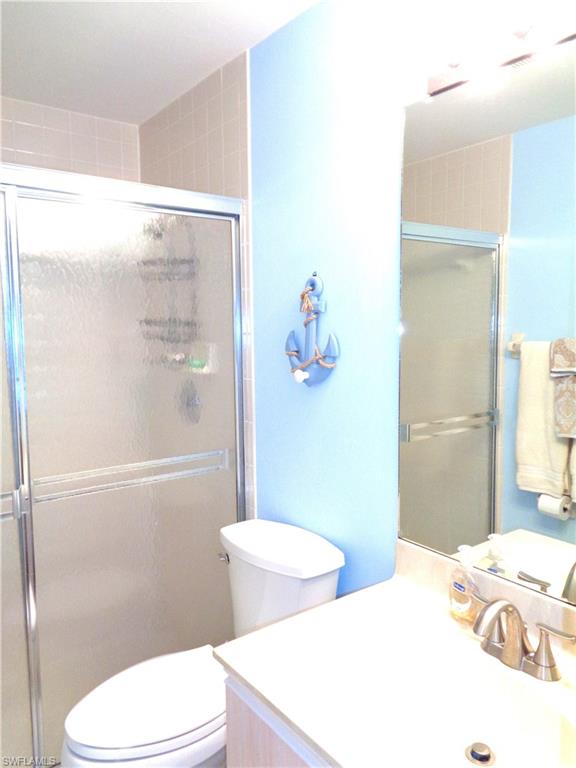 6260 Bellerive Avenue, Unit 4 Naples, FL 34119 - Photo 30 of 36 a bathroom with a toilet a sink and shower