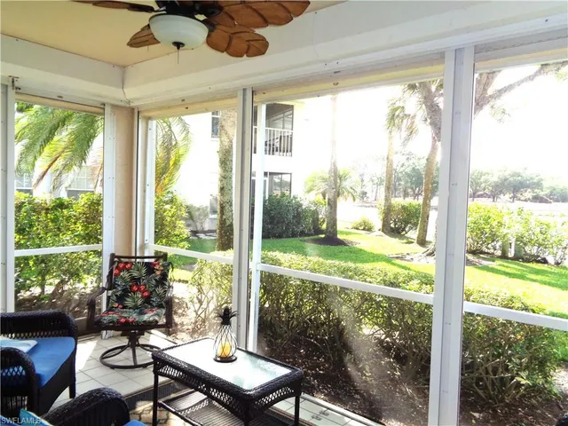 a view of a room that has a bed and a table in it