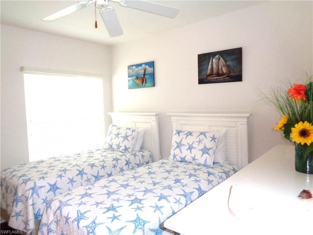 6260 Bellerive Avenue, Unit 4 Naples, FL 34119 - Photo 31 of 36 a bedroom with a bed and a painting on the wall