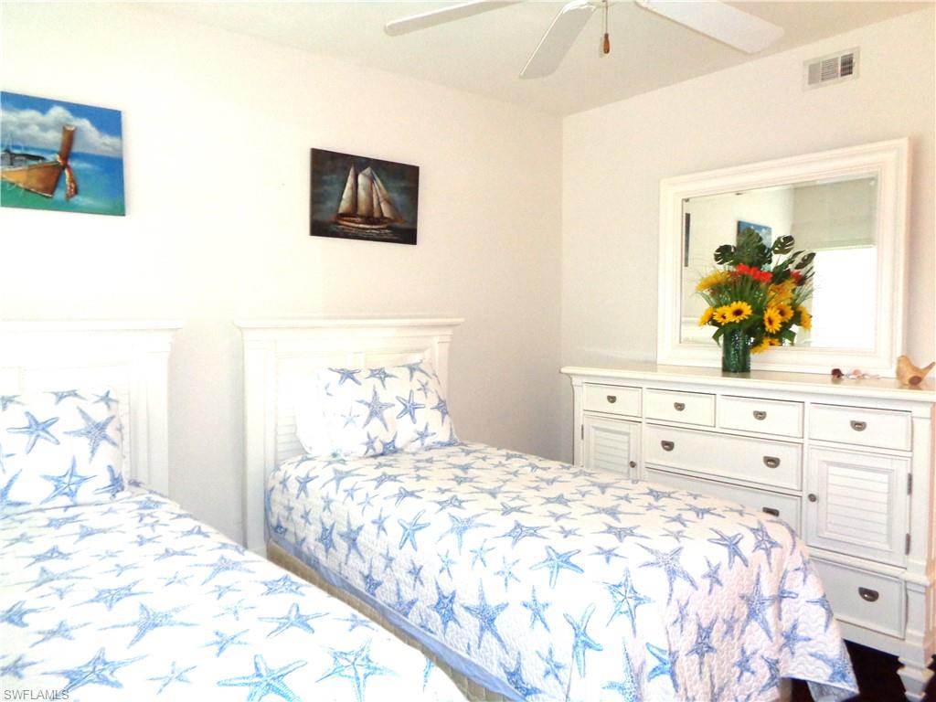 6260 Bellerive Avenue, Unit 4 Naples, FL 34119 - Photo 32 of 36 a bedroom with a bed and a dresser