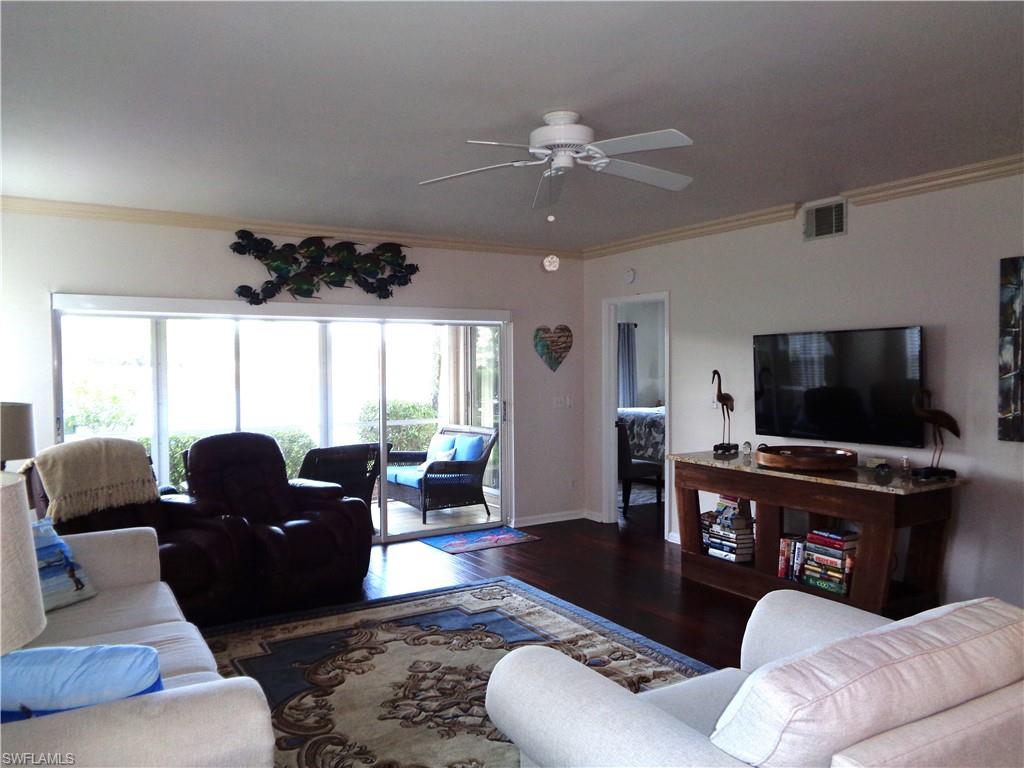 6260 Bellerive Avenue, Unit 4 Naples, FL 34119 - Photo 34 of 36 a living room with furniture and a flat screen tv