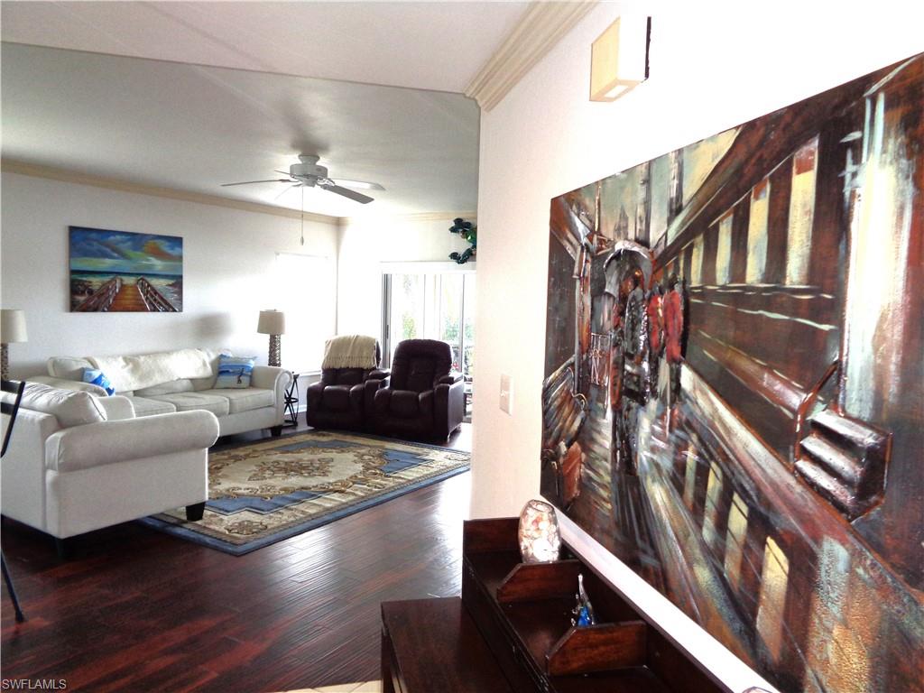 6260 Bellerive Avenue, Unit 4 Naples, FL 34119 - Photo 5 of 36 a living room with furniture hardwood floor and a ceiling fan