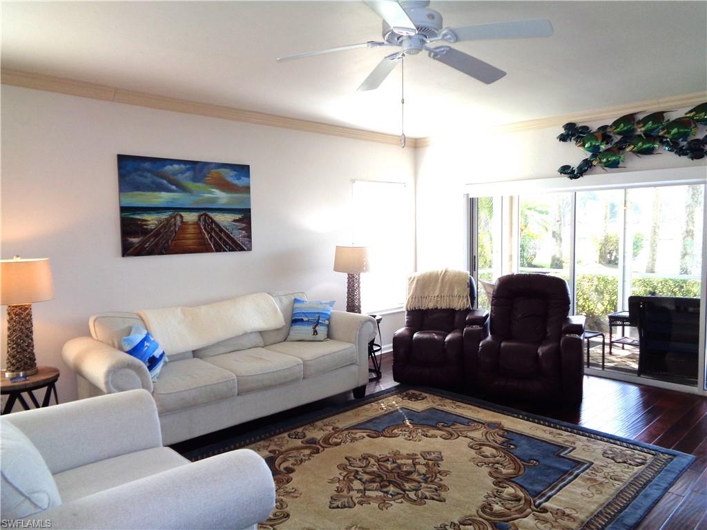 6260 Bellerive Avenue, Unit 4 Naples, FL 34119 - Photo 6 of 36 a living room with furniture and a large window