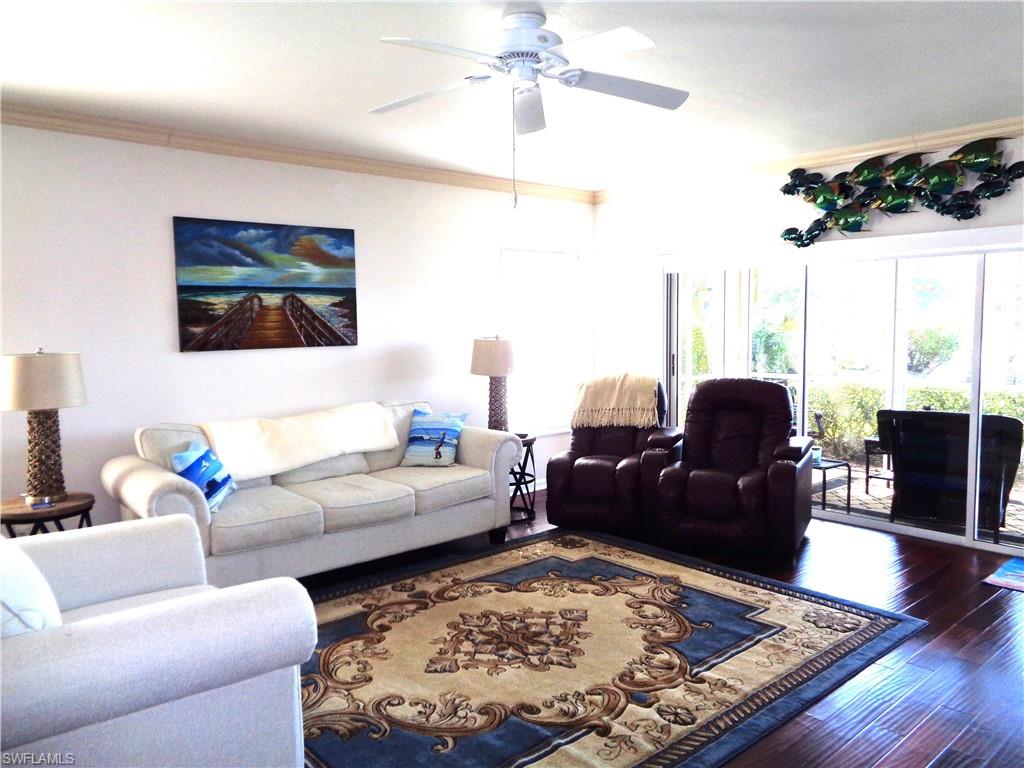 6260 Bellerive Avenue, Unit 4 Naples, FL 34119 - Photo 7 of 36 a living room with furniture and a rug