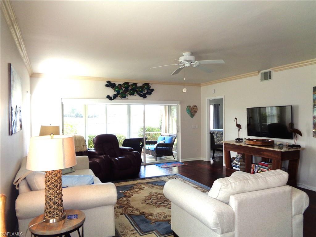 6260 Bellerive Avenue, Unit 4 Naples, FL 34119 - Photo 8 of 36 a living room with furniture and a flat screen tv