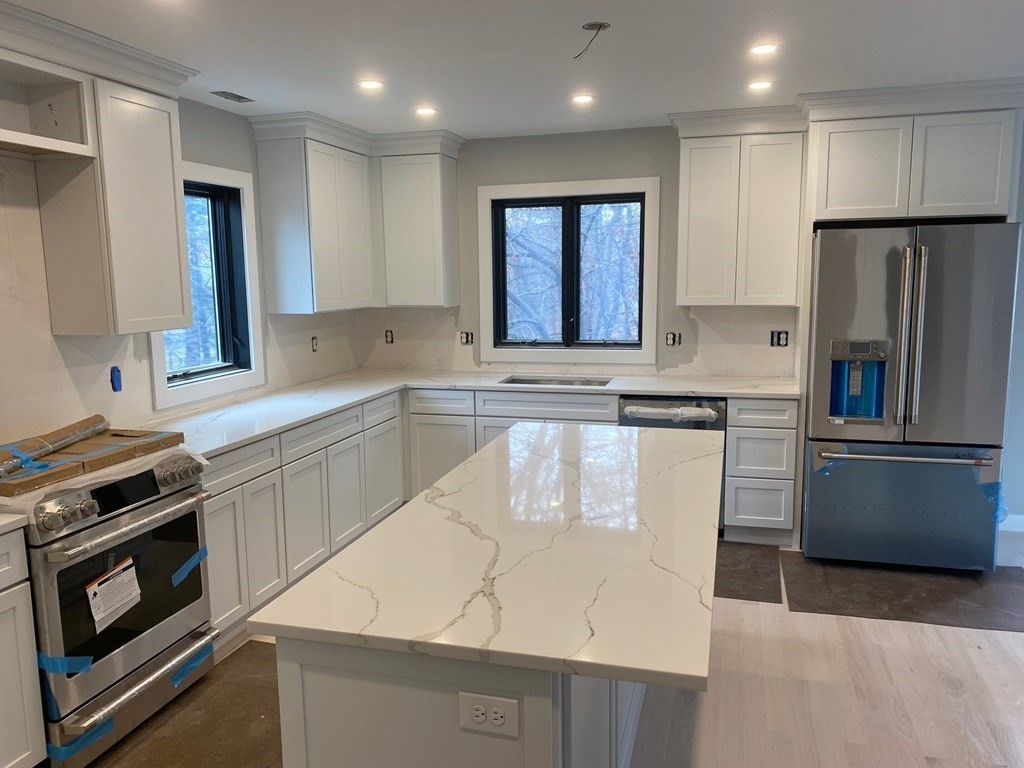 101-103 Warwick Road, Unit 101 Newton, MA 02465 - Photo 5 of 8 a kitchen with stainless steel appliances granite countertop a sink stove and refrigerator