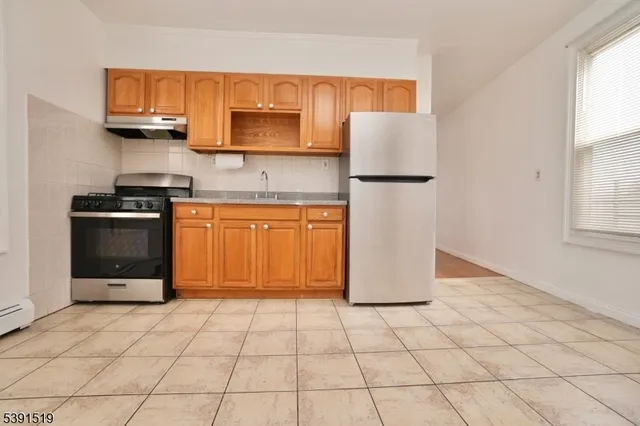 a kitchen with stainless steel appliances granite countertop a refrigerator sink and stove