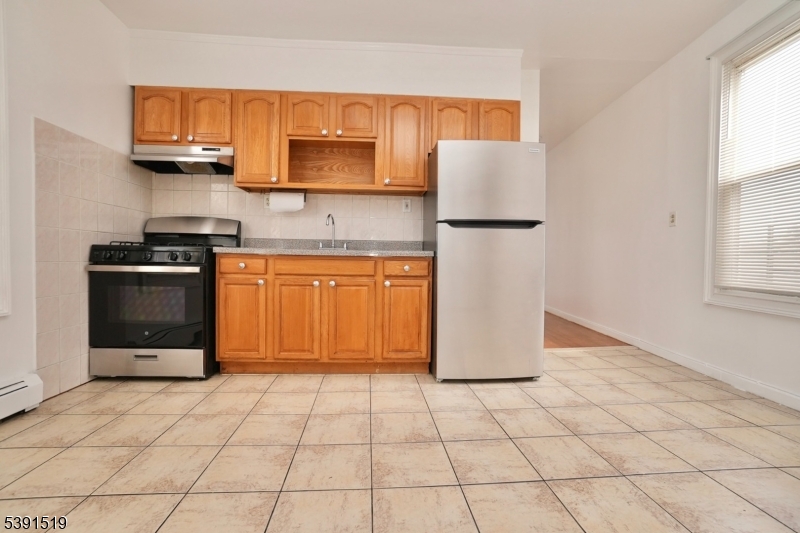 a kitchen with stainless steel appliances granite countertop a refrigerator sink and stove