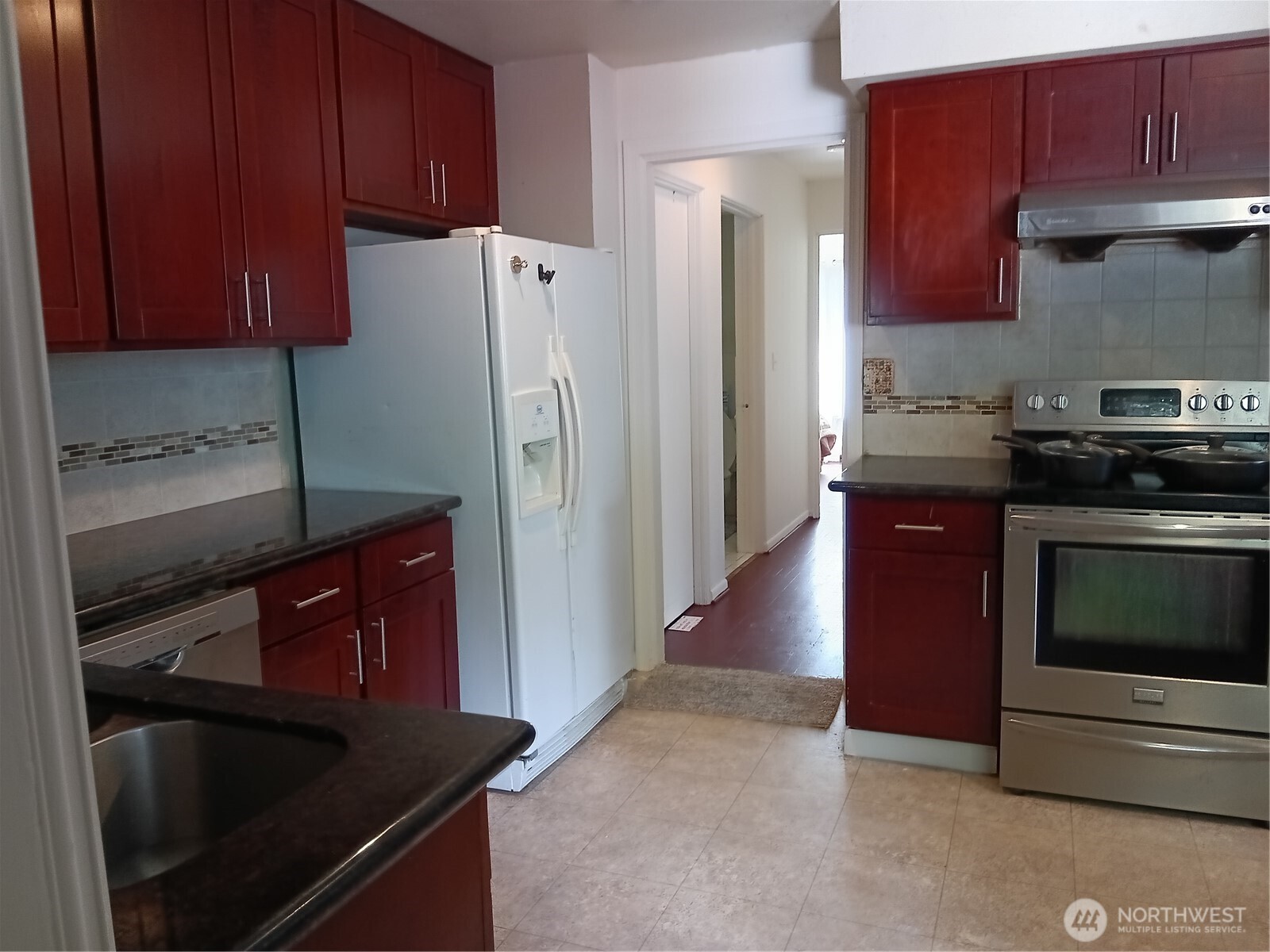 522 Northeast 127th Street Seattle, WA 98125 - Photo 13 of 28 a kitchen with stainless steel appliances granite countertop a refrigerator stove and sink