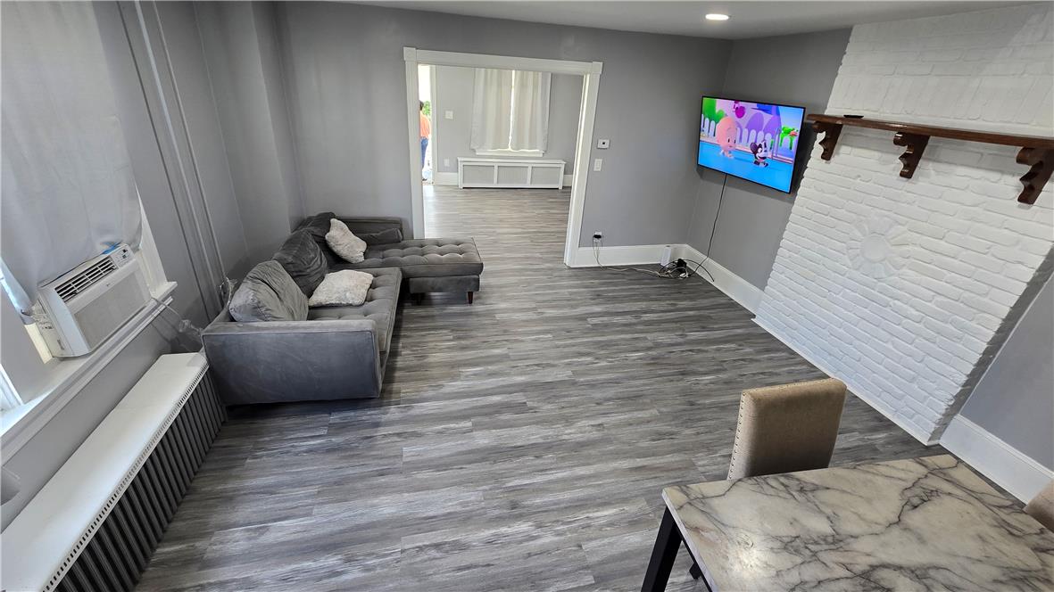 883 North Locust Street Hazleton, PA 18201 - Photo 70 of 83 A versatile living space with light wood-look flooring and a distinctive white brick feature wall.