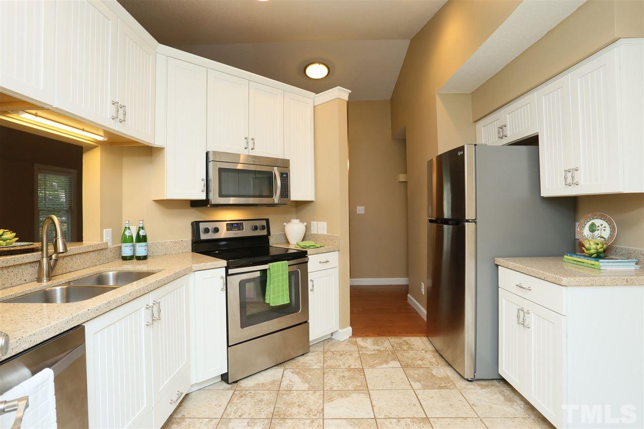 814 Temple Street Raleigh, NC 27609 - Photo 6 of 19 Updated kitchen with white cottage style cabinets, quartz countertops and newer stainless steel appliances.