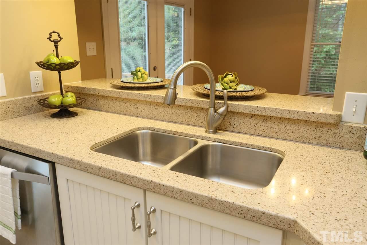 814 Temple Street Raleigh, NC 27609 - Photo 7 of 19 Updated kitchen with white cottage style cabinets, quartz countertops and newer stainless steel appliances. Sink overlooks the large breakfast bar and dining area.