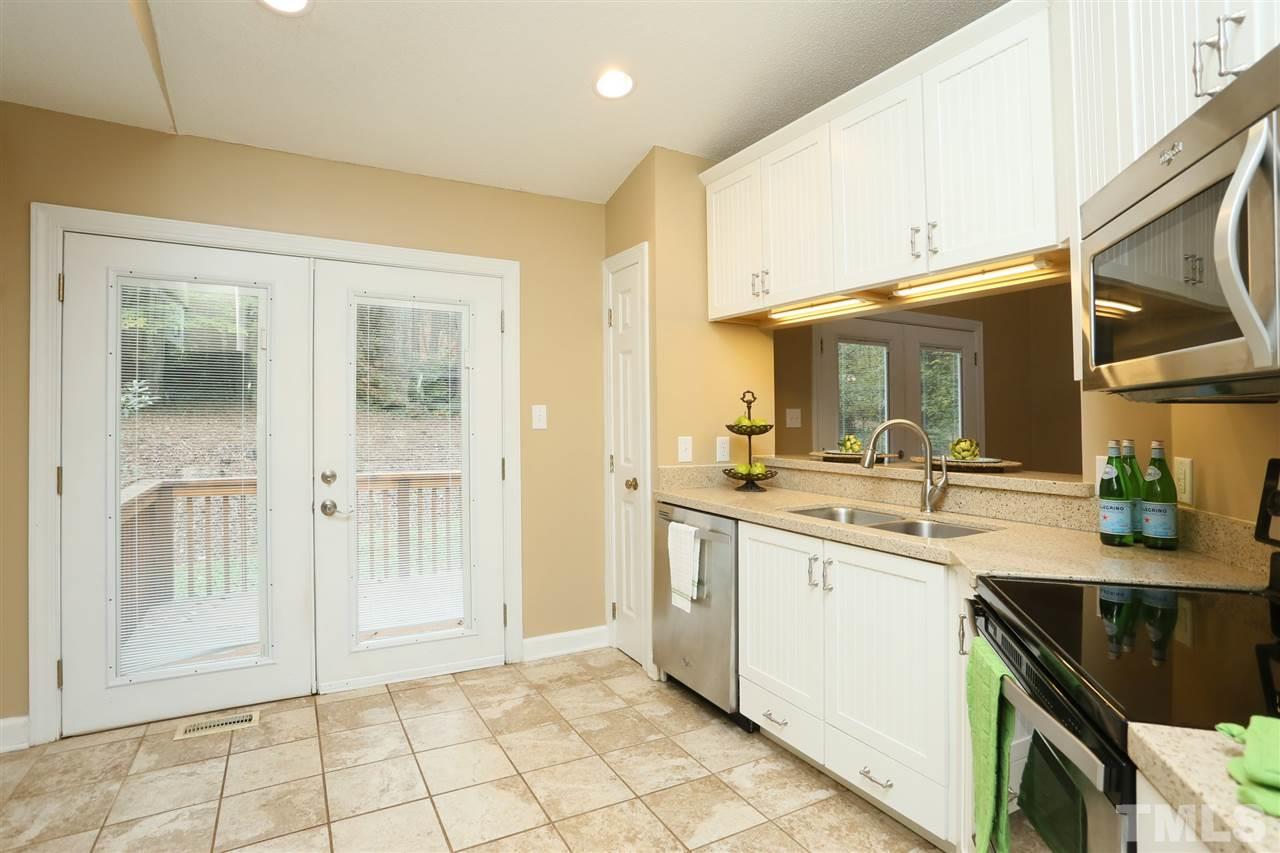 814 Temple Street Raleigh, NC 27609 - Photo 8 of 19 Updated kitchen with white cottage style cabinets, quartz countertops and newer stainless steel appliances.