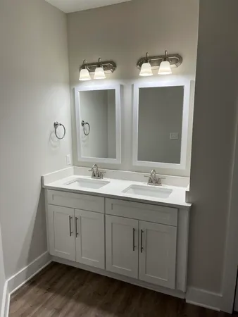 a bathroom with double vanity sinks and a mirror