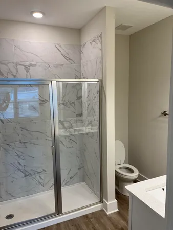 a bathroom with a granite countertop sink mirror and toilet