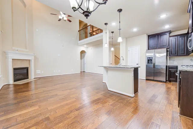 a view of a kitchen with refrigerator and wooden floor