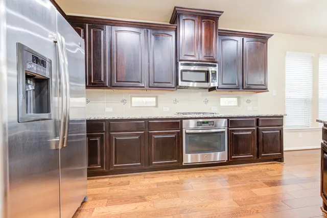 a kitchen with granite countertop stainless steel appliances and wooden cabinets