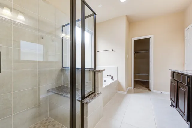 a bathroom with a glass shower door and a sink