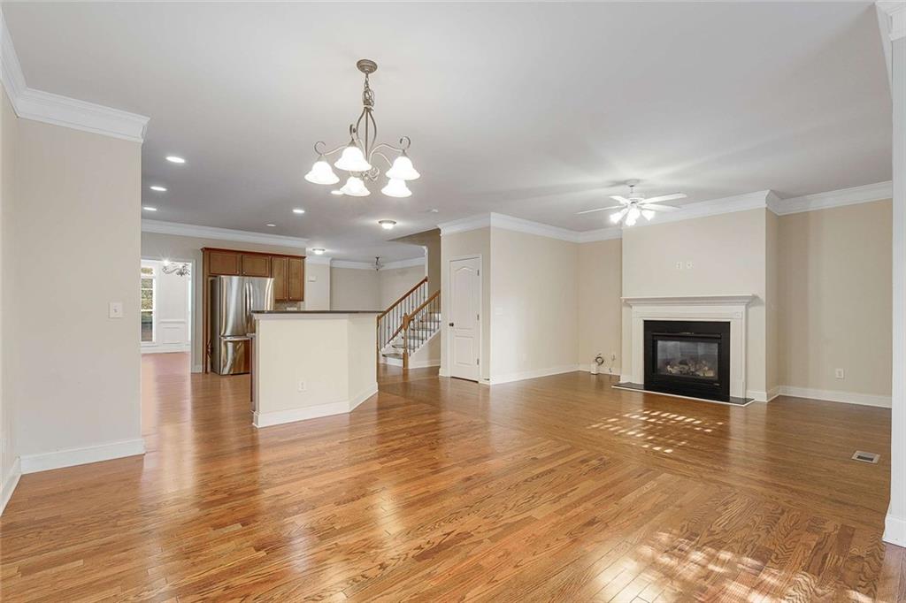 3199 Buck Way Alpharetta, GA 30004 - Photo 18 of 45 a view of a livingroom with a fireplace a chandelier and wooden floor