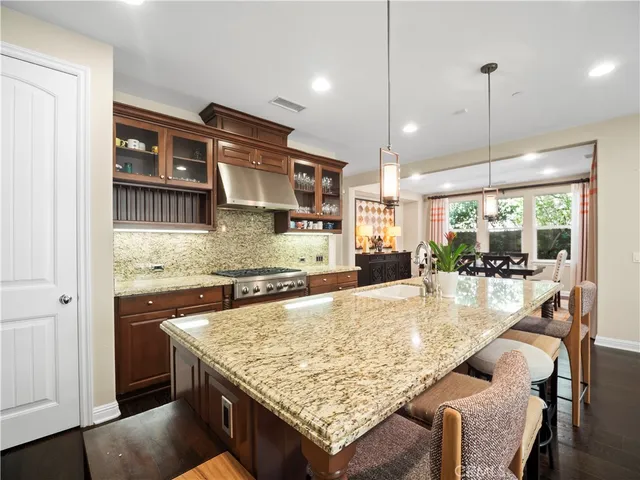 a kitchen with stainless steel appliances granite countertop wooden cabinets a granite counter tops and a view of living room