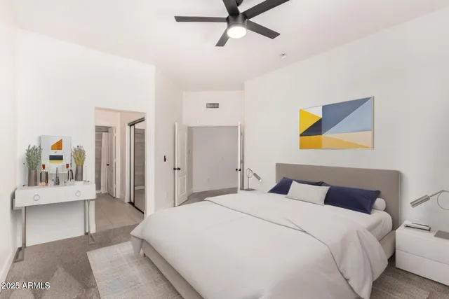 a bedroom with a bed and painting on the wall