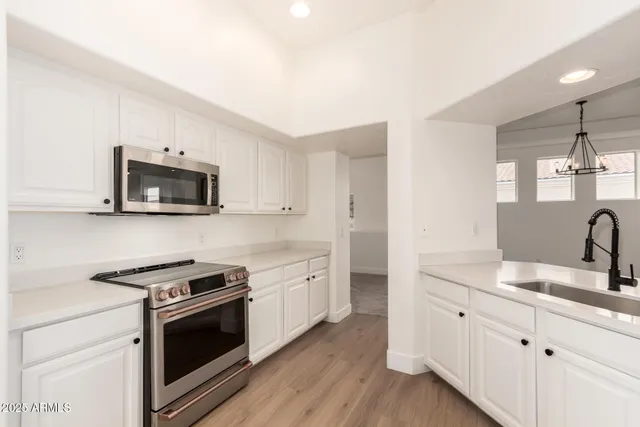 a view of a hallway with wooden floor and a kitchen
