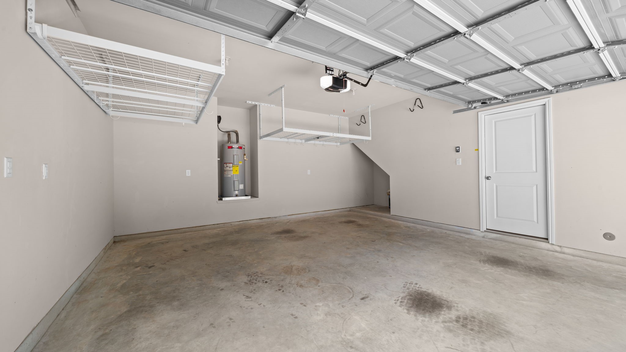 18140 Mail Rte Road Montgomery, TX 77316 - Photo 24 of 26 Generous two-car garage featuring ceiling-mounted storage racks and plenty of room for parking and storage.