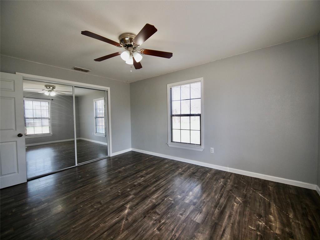 1327 Old Jacksboro Road Graham, TX 76450 - Photo 11 of 33 an empty room with wooden floor fan and windows