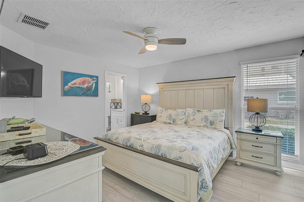 6308 Midnight Pass Road, Unit 6 Sarasota, FL 34242 - Photo 20 of 44 a bedroom with a bed and a flat screen tv
