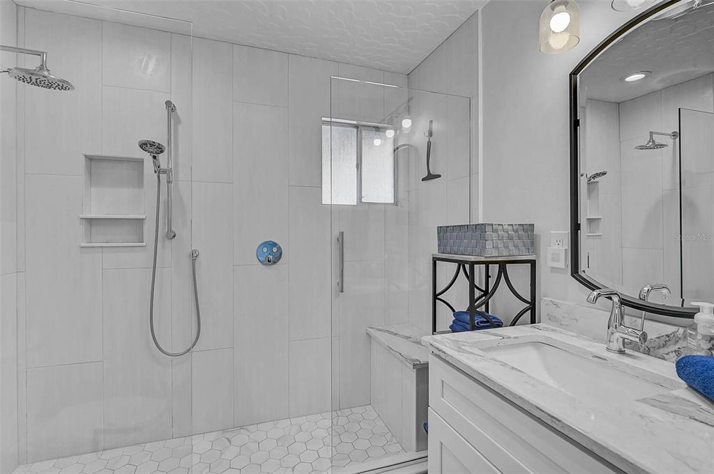 6308 Midnight Pass Road, Unit 6 Sarasota, FL 34242 - Photo 21 of 44 a bathroom with a granite countertop sink a mirror and shower