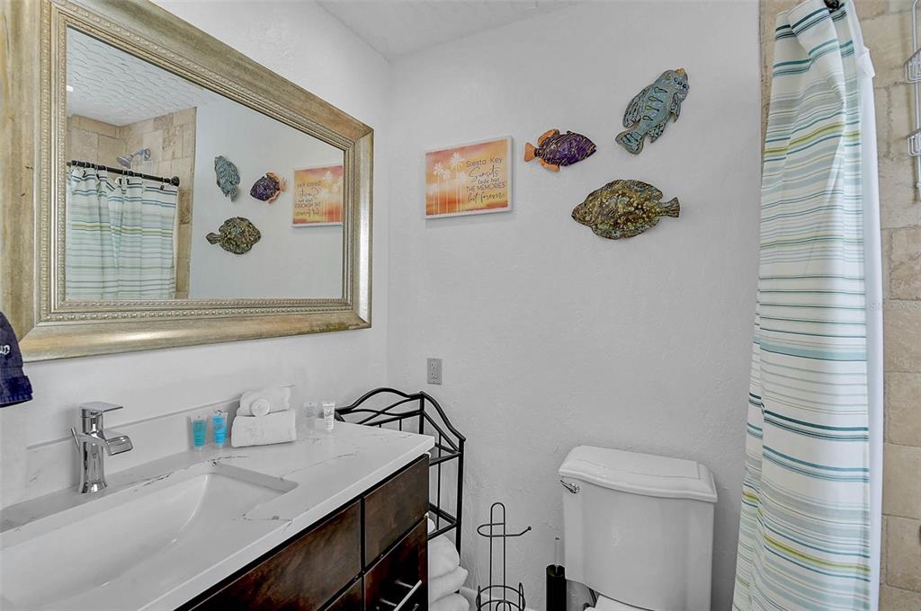 6308 Midnight Pass Road, Unit 6 Sarasota, FL 34242 - Photo 25 of 44 a bathroom with a toilet a sink and a mirror
