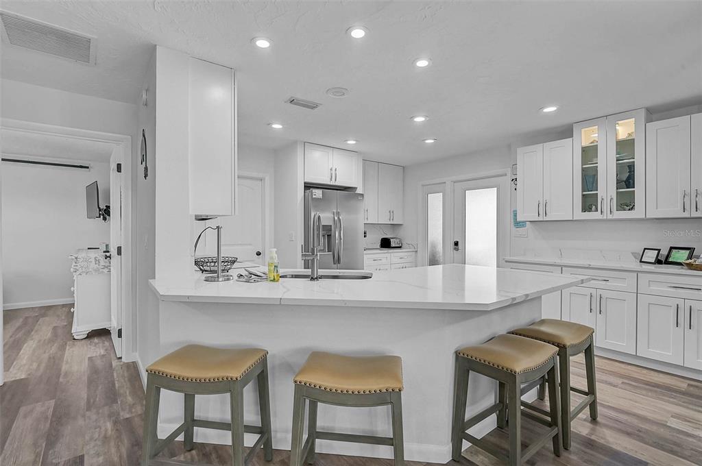 6308 Midnight Pass Road, Unit 6 Sarasota, FL 34242 - Photo 5 of 44 a kitchen with stainless steel appliances kitchen island granite countertop a table chairs sink and cabinets