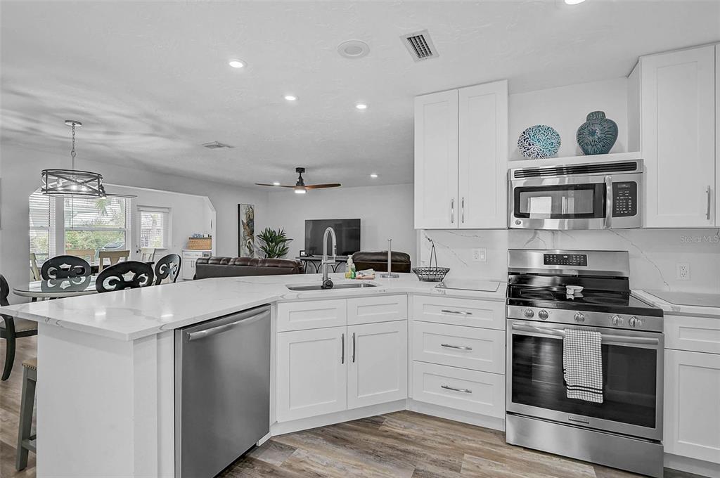 6308 Midnight Pass Road, Unit 6 Sarasota, FL 34242 - Photo 9 of 44 a kitchen with white cabinets and stainless steel appliances