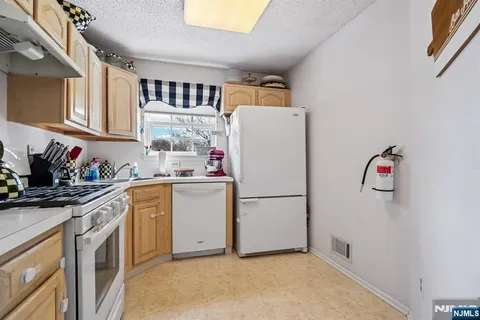 a kitchen with refrigerator cabinets and window
